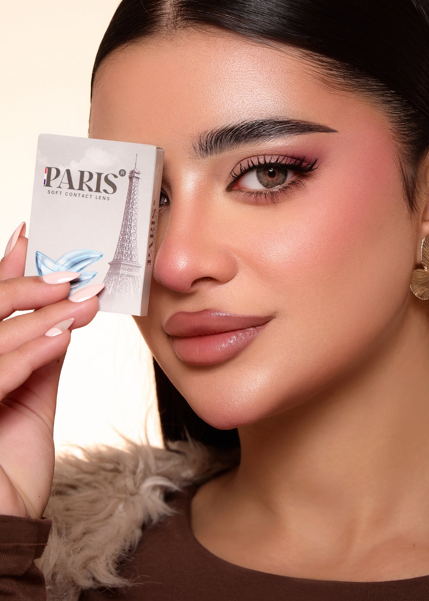 Woman holding a Parisian product packaging close to her face
