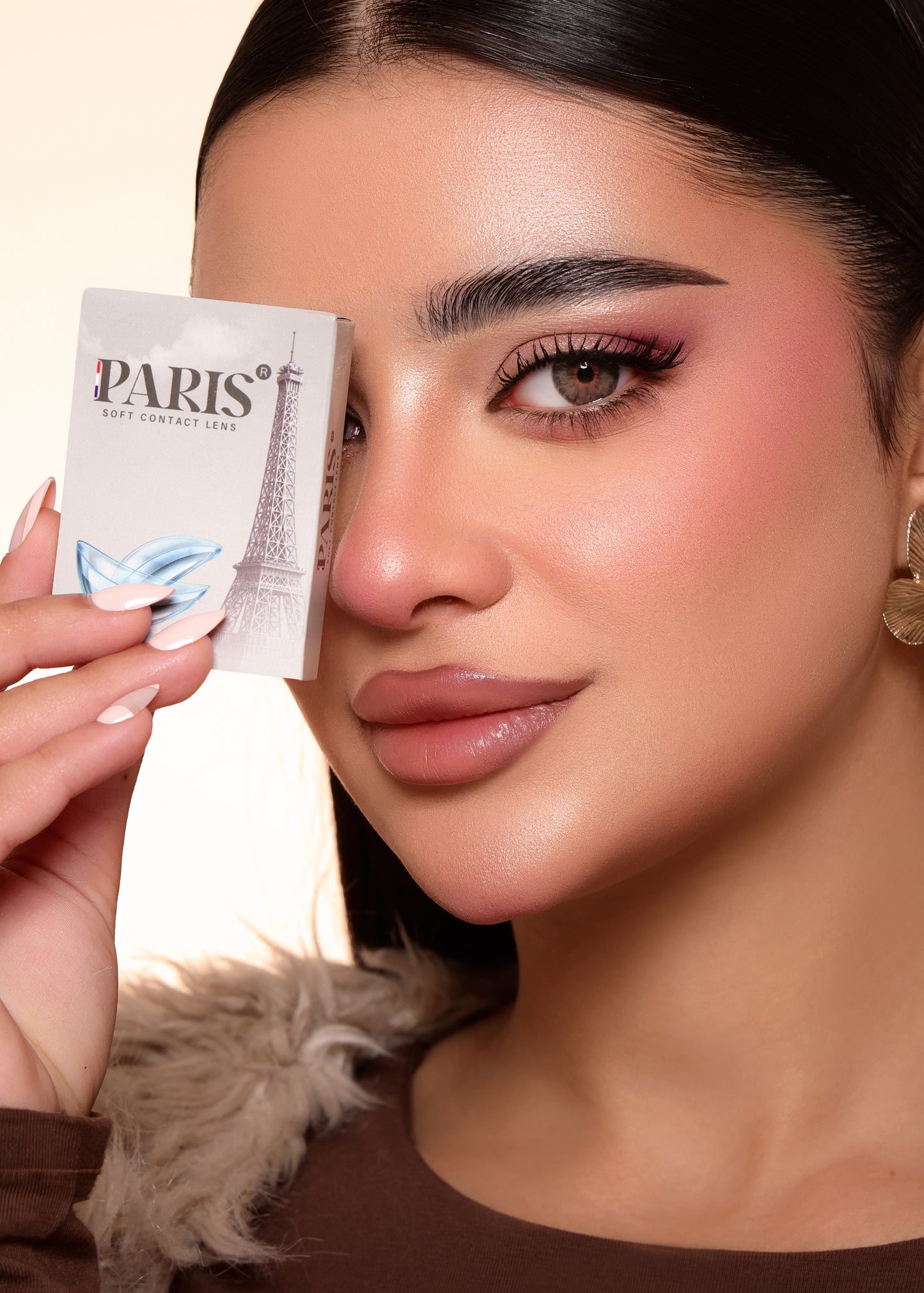 Woman holding a Parisian product packaging close to her face