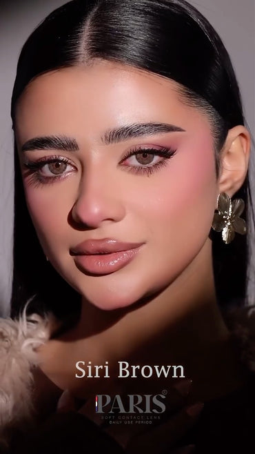 Close-up of a person with makeup and an earring, with 'Siri Brown PARIS' branding.