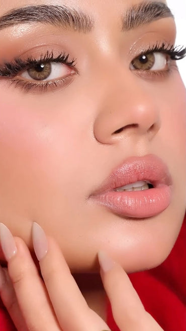 Close-up of a person's face with a gold ring on a red background