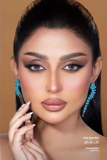 Close-up of a person with makeup and jewelry on a beige background